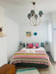a bedroom with a bed with a colorful blanket at A Casa Branca in Mértola