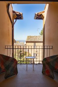 Una vista de un balcón con una mesa y sillas. en Palazzo Misciattelli - Ripalta Luxury Residence, en Orvieto