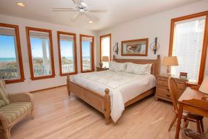 Un dormitorio con una cama y un sofá y ventanas. en OCEANFRONT, Private Pool, Ocean Views, Private Beach Access, PI250, Windrift, en Sanderling 62 fotos más