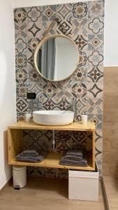 bagno con lavandino e specchio a parete di Wanderlust house a Bari