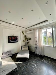 dream villa في تبليسي: غرفة معيشة مع أريكة ونافذة