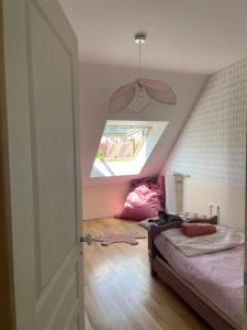 a attic bedroom with a bed and a window at Les chambres de Juliette in Moulins