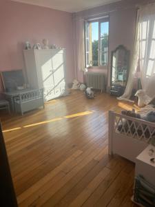 uma sala de estar com piso de madeira em Les chambres de Juliette em Moulins