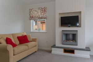 a living room with a couch and a tv at 46 Meadow View in Woolacombe +12 photos
