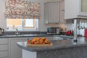 a kitchen with a cutting board with croissants on a counter at 46 Meadow View in Woolacombe