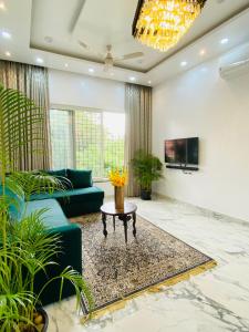 Laxmi Villa 3BHK Premium Villa with terrace Anjuna في أنجونا: غرفة معيشة مع أريكة وطاولة
