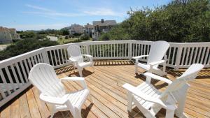 une terrasse en bois avec des chaises blanches dans l'établissement Oceanside, Hot Tub, Community Amenities, 845 ft to Beach Access, PI6, Fan-ta-sea, à Corolla