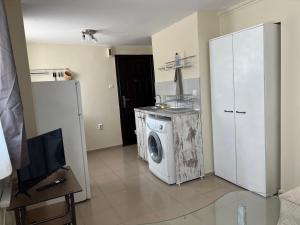 a washing machine in a room with a tv at Studio 5 in Varna City