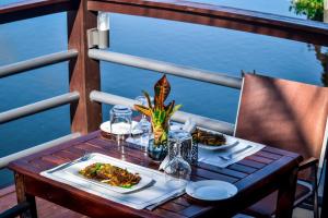 a table with two plates of food on a balcony at Royal Riverside Lodge in Big Ada