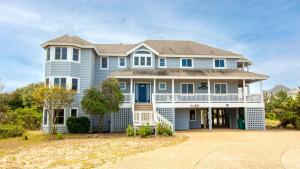 a large blue house with a large driveway at Oceanside, 7 BRs, Private Pool, Den, Rec Rm, 350 ft to Beach access, PI54, Fore Sea Suns in Corolla