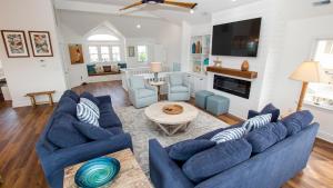a living room with blue couches and a table at Oceanside, 7 BRs, Private Pool, Den, Rec Rm, 350 ft to Beach access, PI54, Fore Sea Suns in Corolla