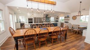 a kitchen with a large wooden table and chairs at Oceanside, 7 BRs, Private Pool, Den, Rec Rm, 350 ft to Beach access, PI54, Fore Sea Suns in Corolla