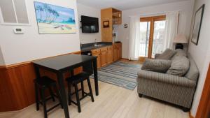 un salon avec une table et un canapé dans l'établissement Oceanside, Private Pool, Volleyball, Screened porch, PI61, Without a Porpoise, à Corolla