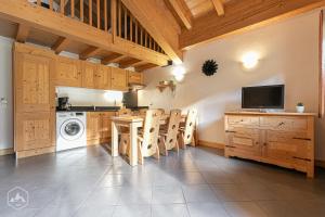 - une cuisine avec des placards en bois, une table et des chaises dans l'établissement Le Marteen’s appartement pour 6 personnes à Val Cenis, à Lanslebourg-Mont-Cenis