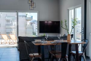 comedor con mesa y sofá en One Shade of Grey Loft with Private Terrace, en Atenas