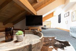 een woonkamer met een tv en een tafel bij Le Marteen’s appartement pour 6 personnes à Val Cenis in Lanslebourg-Mont-Cenis