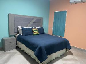 um quarto com uma cama com lençóis e almofadas azuis em Condominio puerto peñasco 2 em Puerto Peñasco