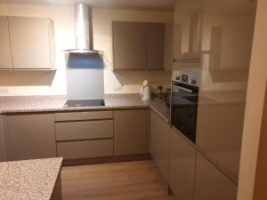 a kitchen with white cabinets and a stove at Immaculate 3-Bed House in Bristol in Bristol