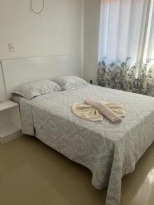 Una cama con dos toallas encima. en Lindo Apartamento a beira Mar- Praia do Muta en Porto Seguro