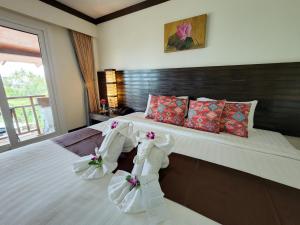 a bedroom with a large bed with two bridal shoes at Lanta Mermaid Boutique House in Ko Lanta
