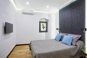 a bedroom with a bed with blue and purple pillows at SERRANO GOLDEN MILE, by Presidence Rentals in Madrid