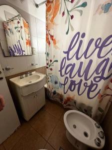 a bathroom with a toilet and a shower curtain at Departamento Las Heras in Mar del Plata