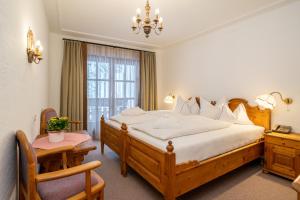 a bedroom with a large bed and a window at Hotel Trattlerhof in Bad Kleinkirchheim