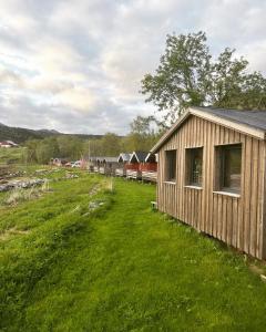 un pequeño edificio de madera en un campo de césped en Base Camp Hamarøy en Sørkil