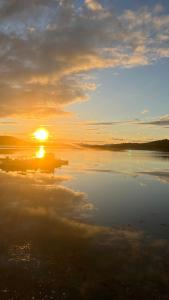 um pôr do sol sobre um corpo de água com o pôr do sol em Base Camp Hamarøy em Sørkil