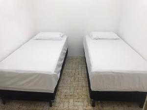 two twin beds in a room with white walls at Apartamento Boa Vista in Garanhuns