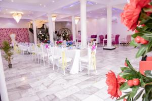 un salón de banquetes con mesas blancas, sillas y flores en PINORICH VILLA-Buea, en Buea