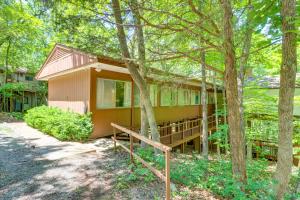 a house in the woods with a porch and trees at Woodsy Mountain Home Escape Walk to Marina! in Mountain Home