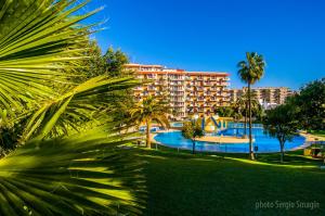 ein Resort mit einem großen Pool und Palmen in der Unterkunft 532 Minerva Apartamentos- Vistas al mar y a la piscina - Excelente Ubicación in Benalmádena