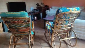 2 sillas con cojines azules sentadas junto a una mesa en La casa del fresno, en Pinilla del Valle