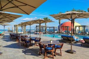 a resort with a pool and tables and umbrellas at Zen Vacation Rentals Ocean Front at Lyfe Resort in Hollywood