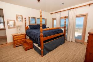 Un dormitorio con una cama y un balcón con vista al mar. en PI76, Life of Reilly- Oceanfront, Ocean Views, Private Pool, Private Beach Access, Foosball, en Corolla