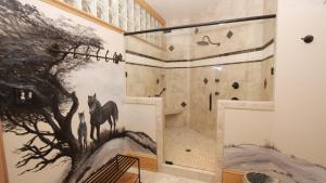 Una ducha con un mural de caballos en la pared. en PI76, Life of Reilly- Oceanfront, Ocean Views, Private Pool, Private Beach Access, Foosball, en Corolla