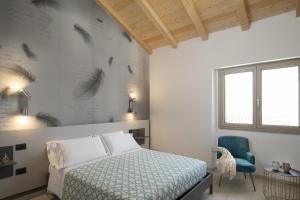 um quarto com uma cama e uma cadeira azul em Theodore Rooms em San Teodoro