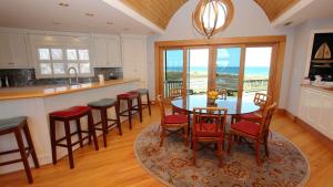 a kitchen with a table and chairs with a view of the ocean at OCEANFRONT, Amazing Ocean and Sound Views, Scrnd Porch, PM1, Ariel in Sanderling