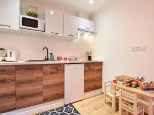 een keuken met een witte koelkast en een tafel bij Apartamenty u Petuski in Szaflary