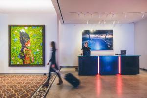 a woman standing at a counter in an art exhibit at 21c Museum Hotel Kansas City in Kansas City