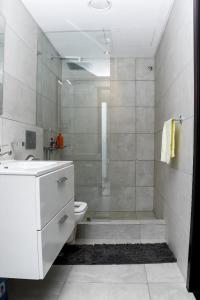 een badkamer met een douche, een toilet en een wastafel bij A307 Luxury 1 Bedroom in Accra