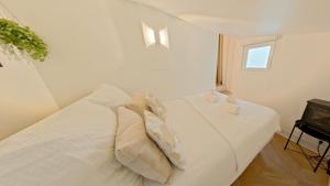 a bedroom with a white bed with pillows on it at Appartement Gare de Lyon in Paris