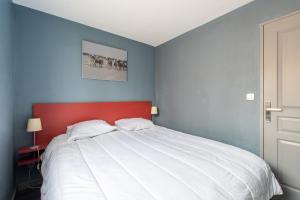 una camera da letto con un letto grande con testiera rossa di Le Mayflower a Le Grau-du-Roi Altre 6 foto