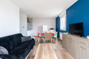 un soggiorno con un divano nero e un tavolo di Le Mayflower a Le Grau-du-Roi