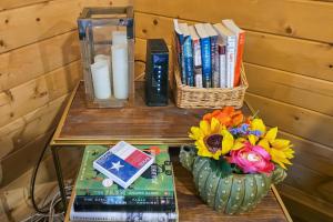 una mesa con un jarrón de flores y libros en Doss-Spring Creek Cabin, en Tivydale