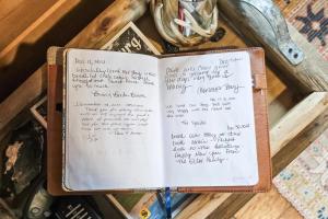 un libro con escritura sentado en una mesa en Doss-Spring Creek Cabin, en Tivydale