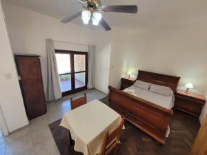 a bedroom with a bed and a table and a ceiling fan at Apart Mirador del lago- Solo para adultos in Las Rabonas