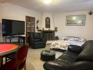 sala de estar con sofá y TV en La casa di Mary en Castiglion Fiorentino