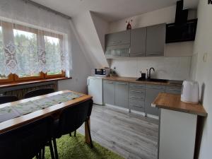 a kitchen with a table and a dining room at Pokoje Gościnne u Lańdy in Poronin